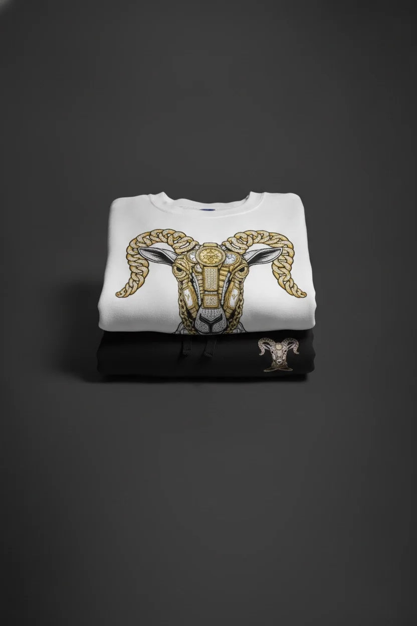 White crewneck sweatshirt folded, gold snake-gem graphic on front