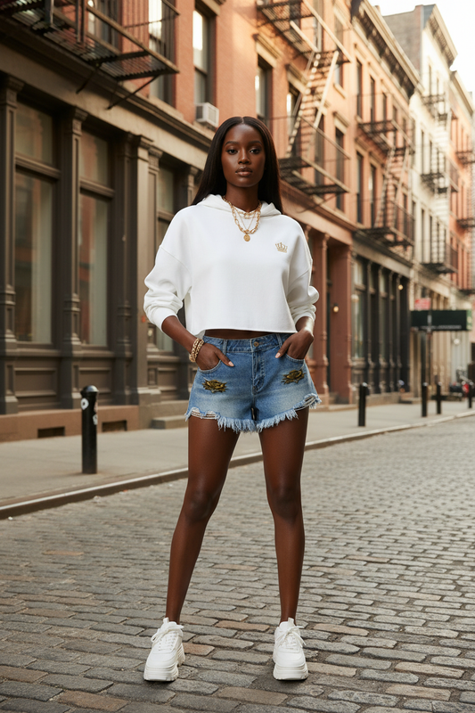 Blue denim shorts with eagle patches and frayed raw hem on a model